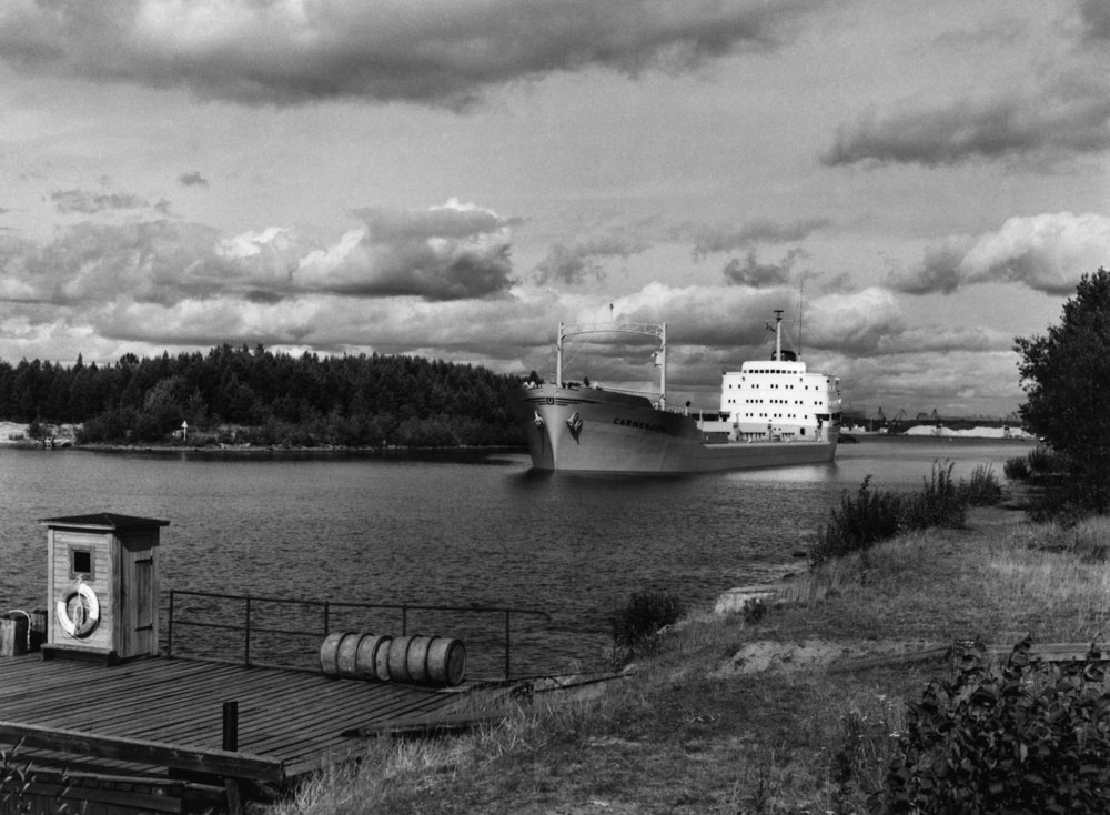 Stort lastfartyg på färd mellan två skärgårdsöar.